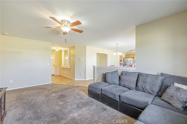 carpeted living room with ceiling fan with notable chandelier