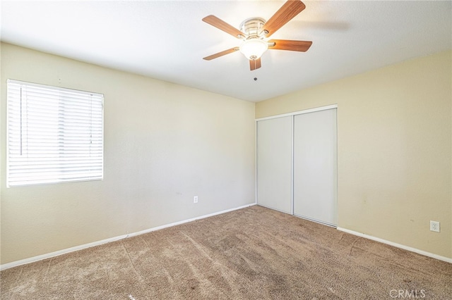 unfurnished bedroom featuring ceiling fan, a closet, and carpet floors