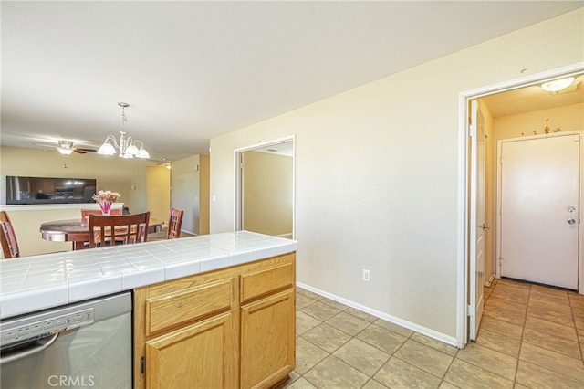 kitchen with stainless steel dishwasher, pendant lighting, light tile patterned flooring, tile countertops, and an inviting chandelier