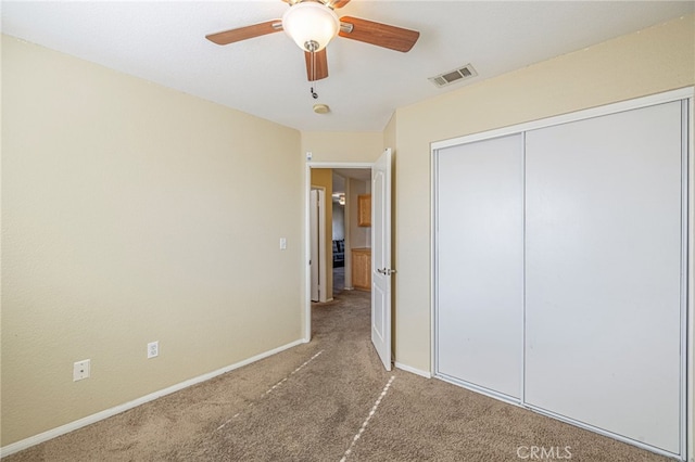 unfurnished bedroom featuring ceiling fan, a closet, and carpet flooring