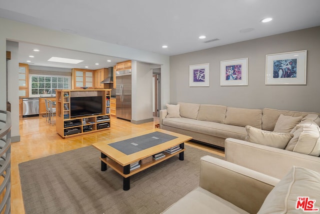 living room featuring sink and light hardwood / wood-style flooring