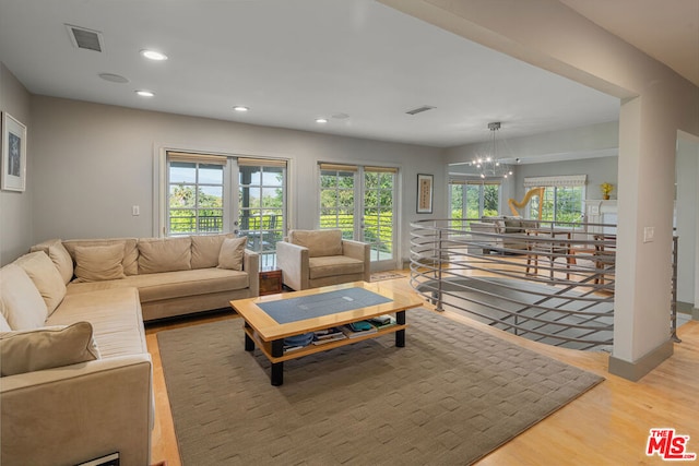 living room featuring hardwood / wood-style floors, french doors, and an inviting chandelier