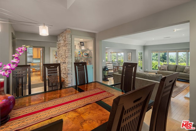 dining space with built in features and light wood-type flooring