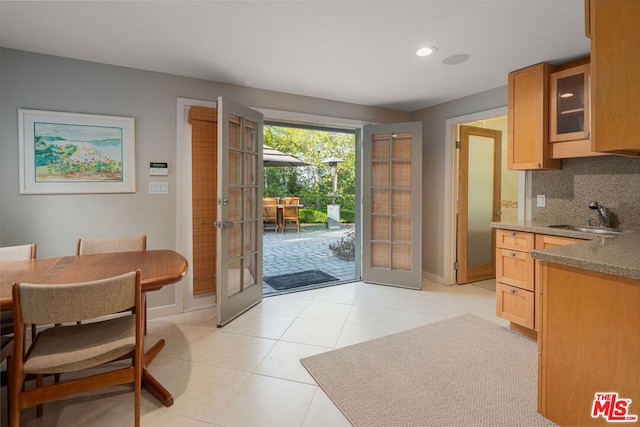 doorway to outside with sink, light tile patterned floors, and french doors