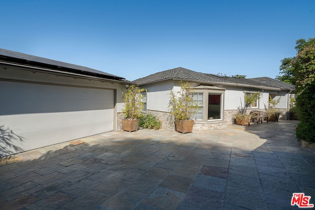 view of front of property featuring a garage and solar panels