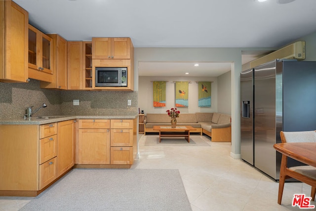 kitchen featuring light stone countertops, appliances with stainless steel finishes, tasteful backsplash, and sink