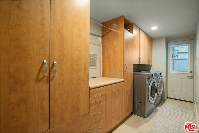 laundry room featuring cabinets and washer and dryer