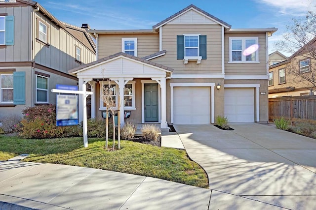 view of property featuring a garage and a front lawn