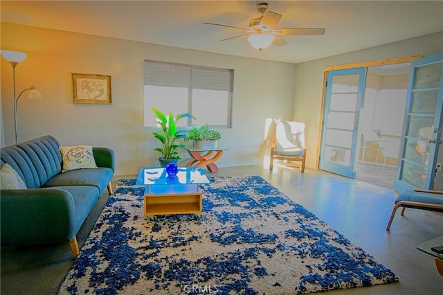 living room with french doors, ceiling fan, and concrete floors