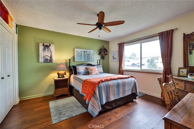 bedroom featuring ceiling fan, dark wood-type flooring, and a textured ceiling