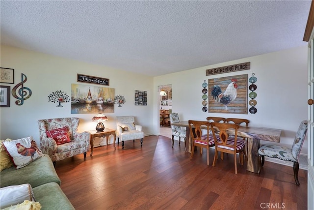 living room featuring dark wood-type flooring and a textured ceiling