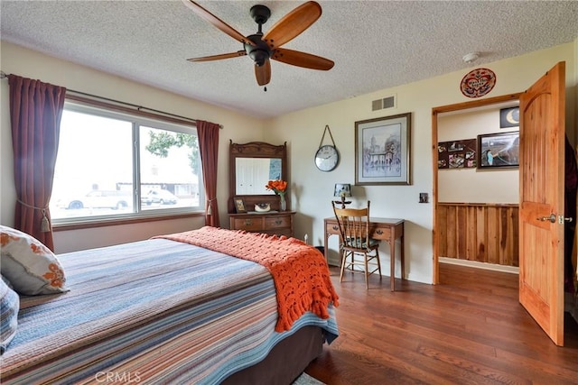 bedroom featuring ceiling fan, dark hardwood / wood-style floors, and a textured ceiling