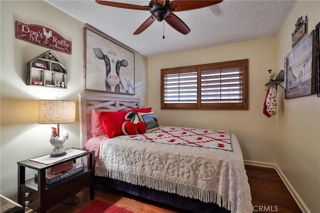 bedroom featuring ceiling fan, hardwood / wood-style floors, and a textured ceiling