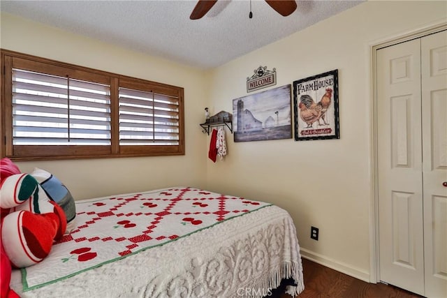 bedroom featuring ceiling fan, dark hardwood / wood-style floors, a closet, and a textured ceiling