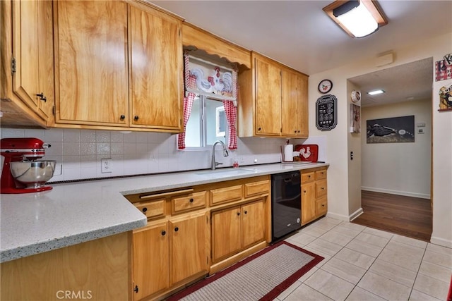 kitchen featuring light tile patterned flooring, sink, light stone counters, dishwasher, and decorative backsplash