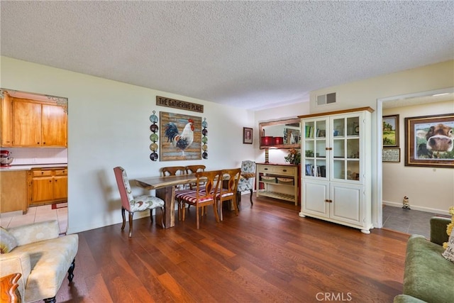 dining space with wood-type flooring and a textured ceiling