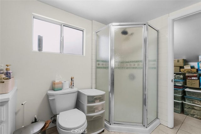 bathroom with tile patterned flooring, toilet, and walk in shower