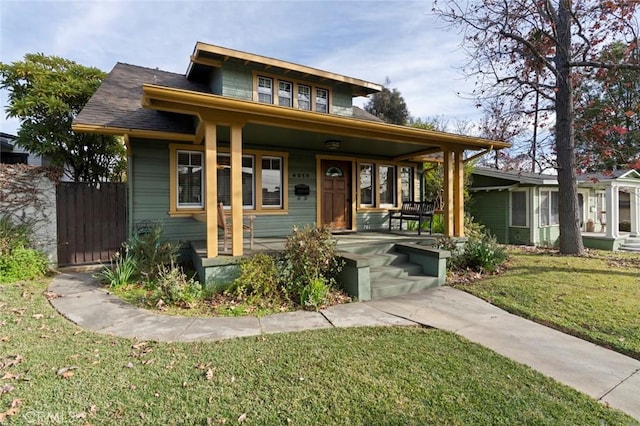 bungalow-style house featuring covered porch and a front lawn