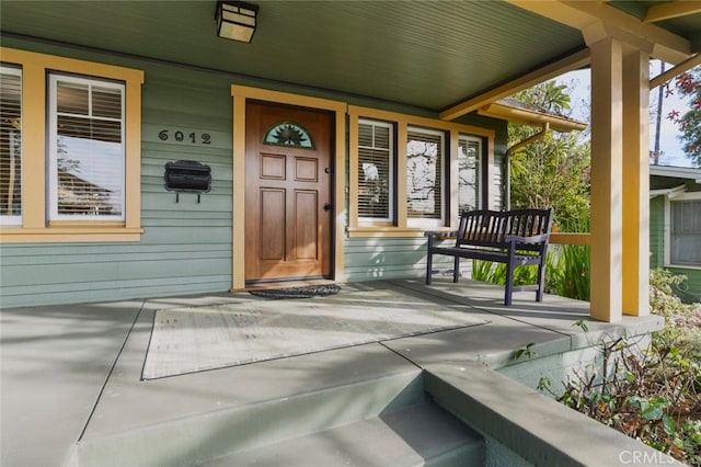 view of exterior entry featuring covered porch