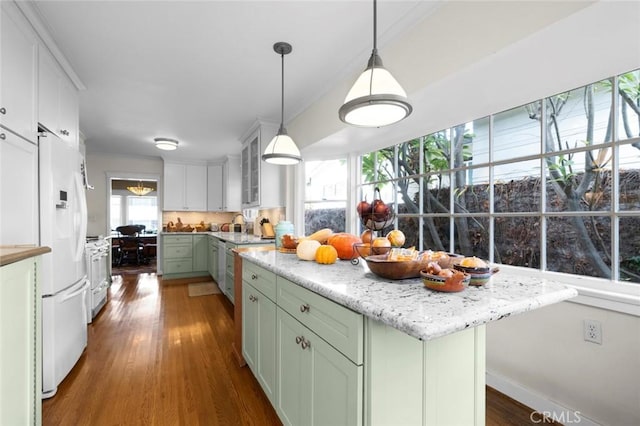 kitchen featuring dark hardwood / wood-style flooring, white fridge with ice dispenser, green cabinetry, and a kitchen island