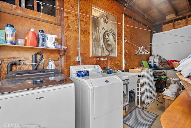 laundry room featuring washing machine and dryer and wood walls