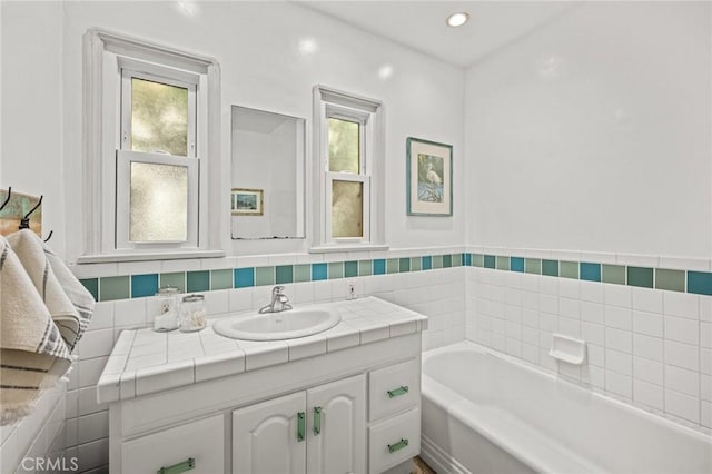 bathroom with plenty of natural light, vanity, and a bathtub