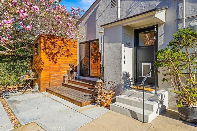 view of exterior entry with a patio area