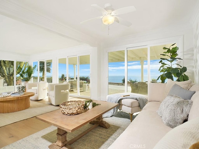 sunroom / solarium featuring a water view and ceiling fan