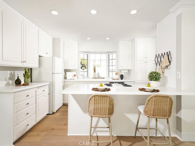 kitchen with white cabinetry, a kitchen breakfast bar, and kitchen peninsula