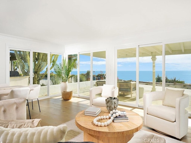 sunroom featuring a water view