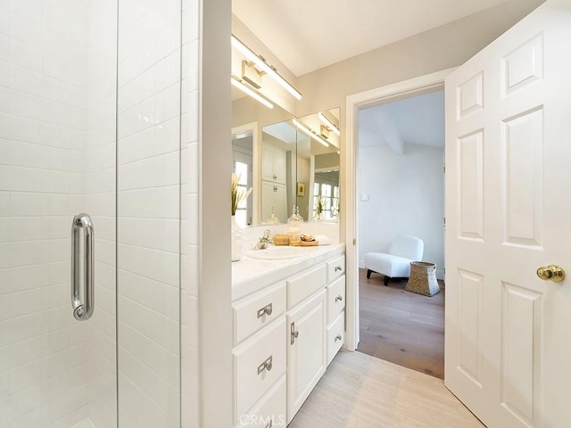 bathroom featuring vanity and a shower with door