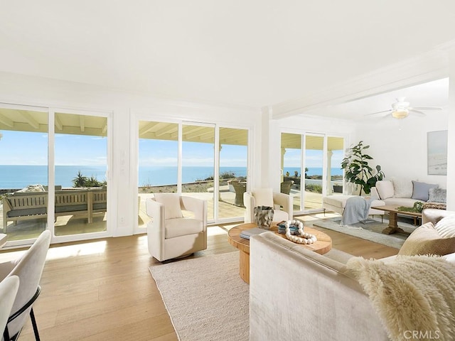 sunroom / solarium with a water view and ceiling fan