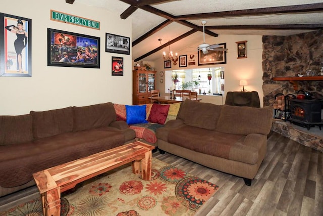 living room with hardwood / wood-style flooring, a wood stove, a notable chandelier, and vaulted ceiling with beams