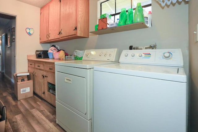 clothes washing area with cabinets, a textured ceiling, dark hardwood / wood-style floors, and washing machine and clothes dryer