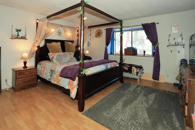 bedroom featuring hardwood / wood-style flooring and a textured ceiling