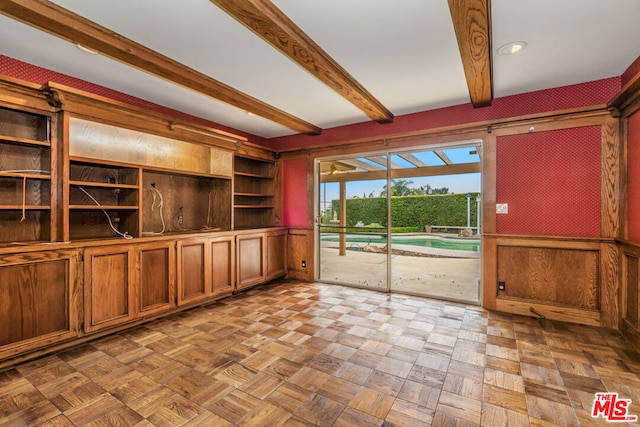 unfurnished living room with light parquet floors and beam ceiling