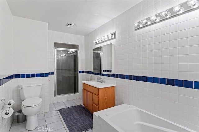 full bathroom featuring tile patterned floors, independent shower and bath, tile walls, and toilet