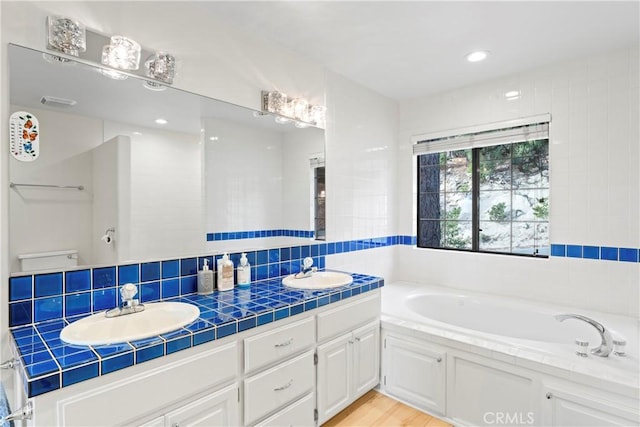 bathroom with hardwood / wood-style flooring, a bathtub, vanity, and toilet