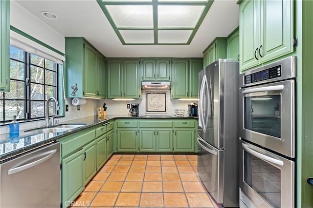 kitchen with sink, light tile patterned floors, green cabinets, and appliances with stainless steel finishes