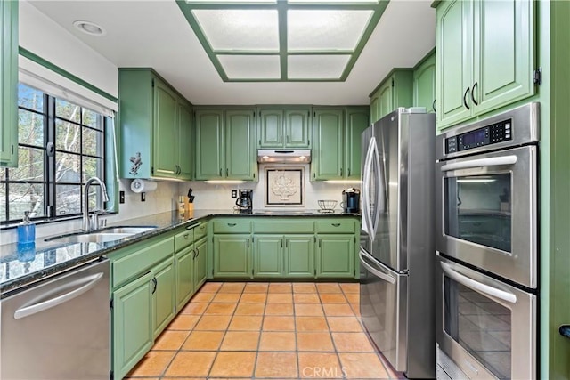 kitchen with light tile patterned floors, stainless steel appliances, green cabinetry, and sink