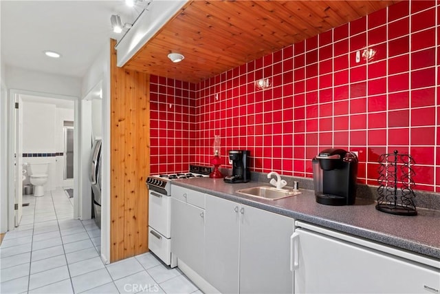 kitchen with sink, white appliances, light tile patterned floors, and track lighting