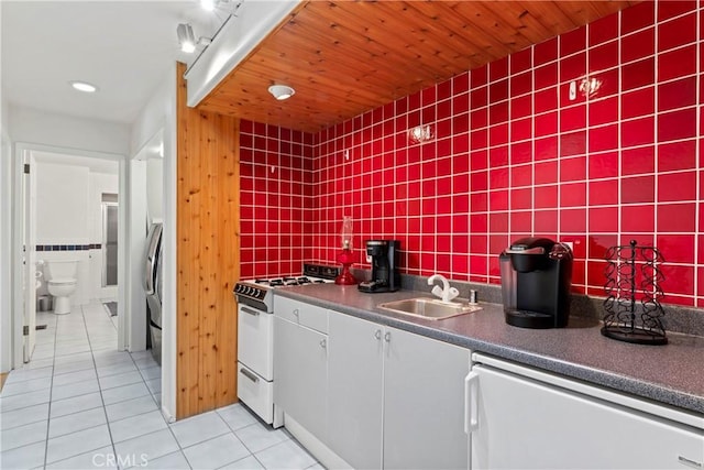 kitchen featuring wood ceiling, sink, white appliances, tasteful backsplash, and light tile patterned floors