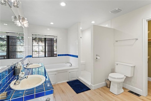 full bathroom with sink, toilet, plus walk in shower, and wood-type flooring