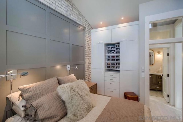 bedroom featuring lofted ceiling and connected bathroom