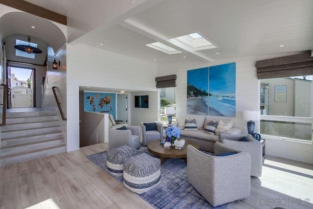 living room with a skylight and light wood-type flooring