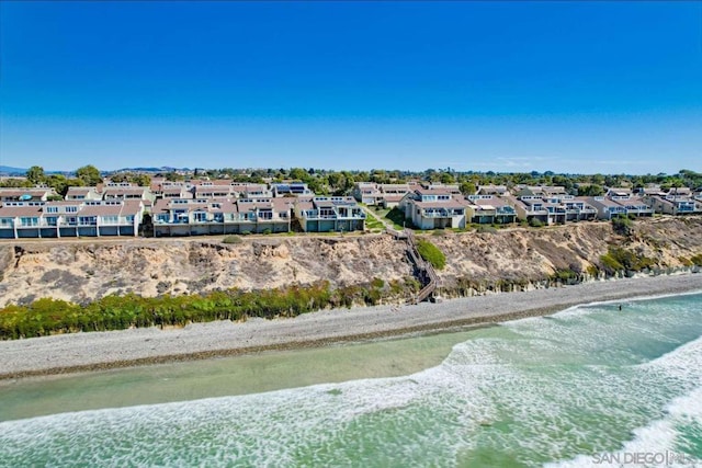 drone / aerial view featuring a water view and a beach view