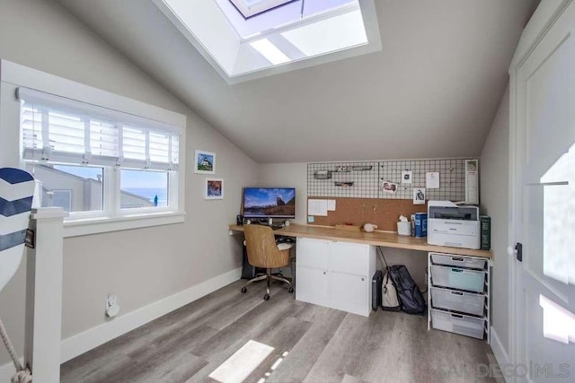 office featuring lofted ceiling with skylight and light wood-type flooring