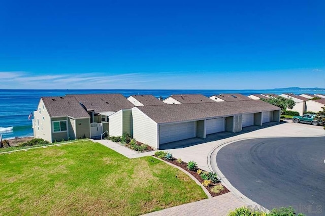 ranch-style house with a front lawn and a water view