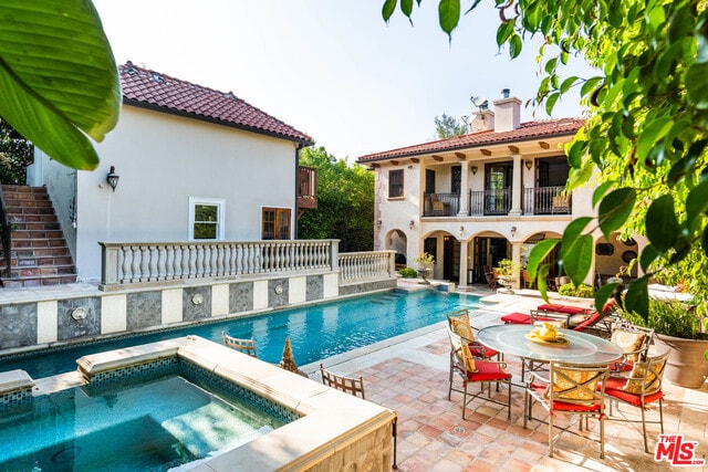 view of pool featuring an in ground hot tub and a patio