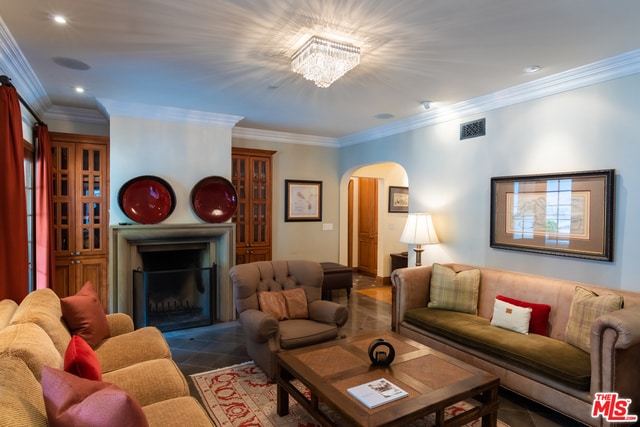 living room with dark tile patterned flooring and crown molding